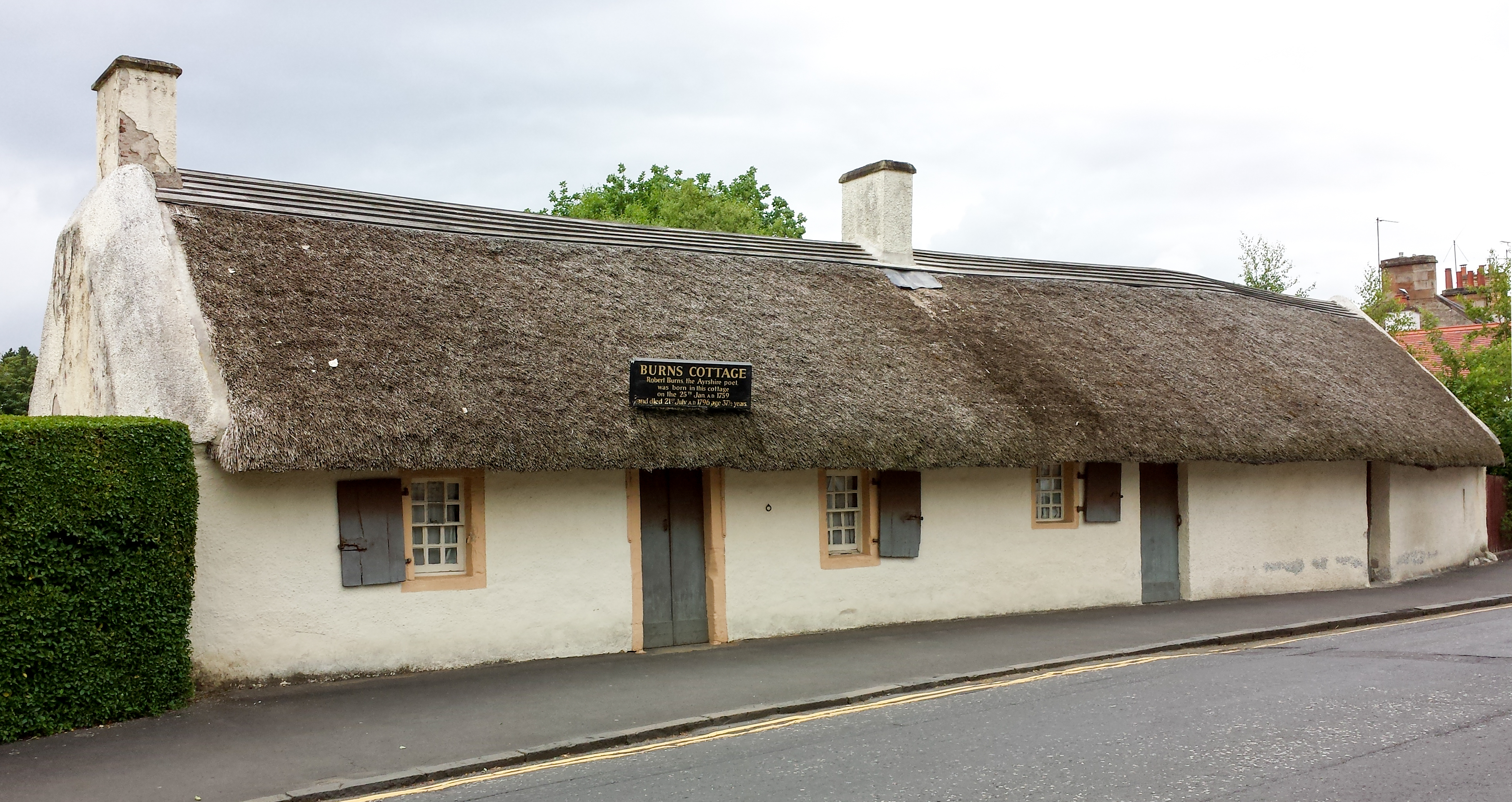 Long whitewashed, thatched Burns Cottage beside the road in Alloway