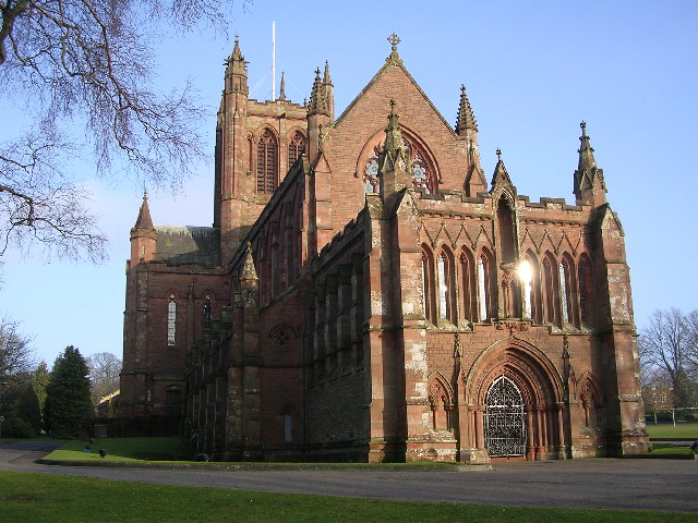 Red sandstone Gothic Revival Crichton Memorial Church, showing its traceried east windows, pinnacles and tower