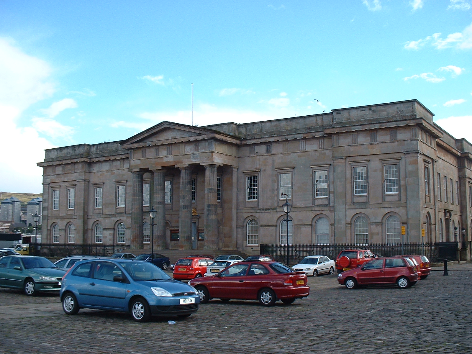Long classical river-facing front of Greenock Custom House, centred on a projecting Doric portico