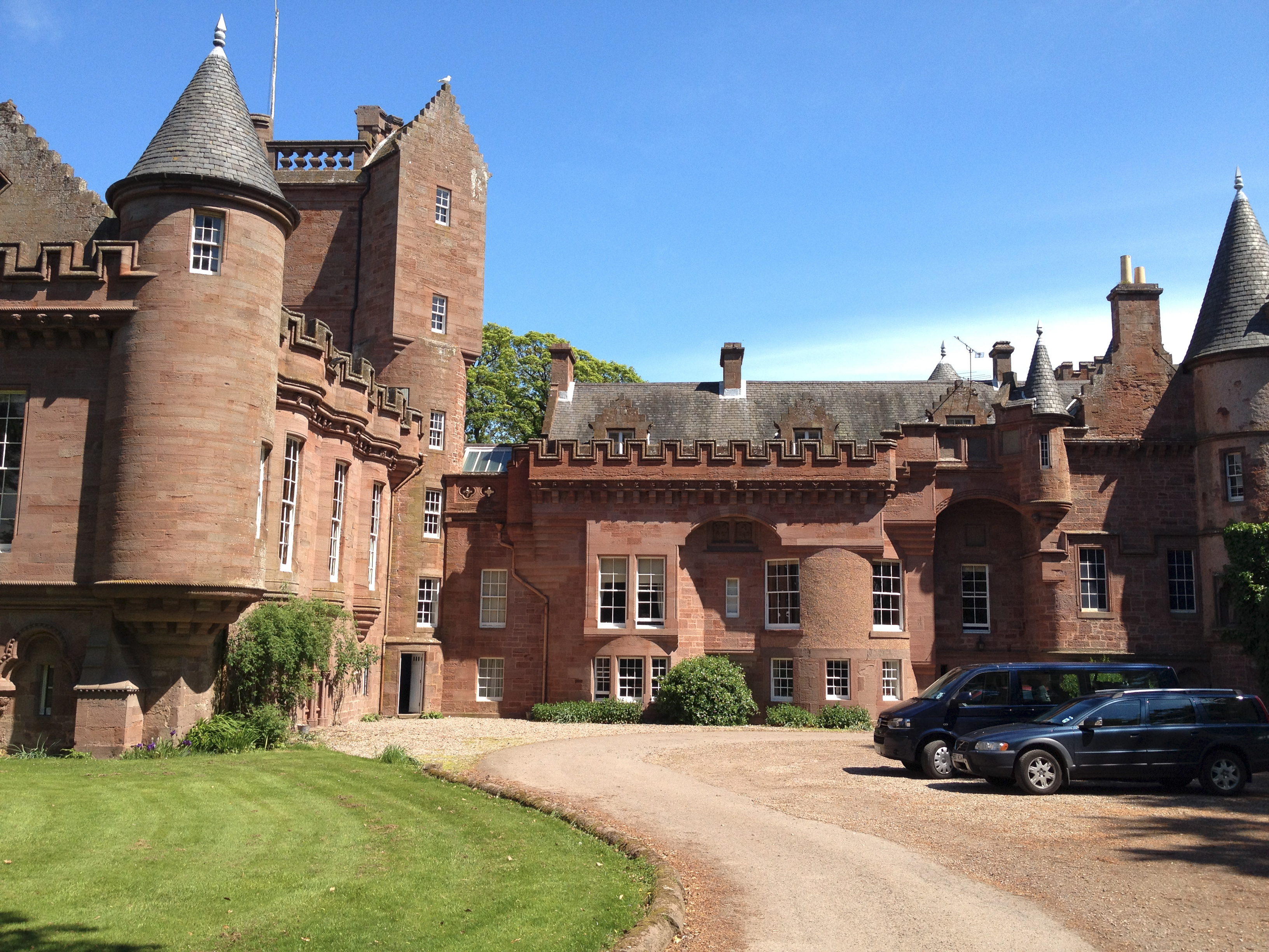 Red sandstone courtyard elevations of Hospitalfield House, with turrets, crow-stepped gables and crenellated parapets