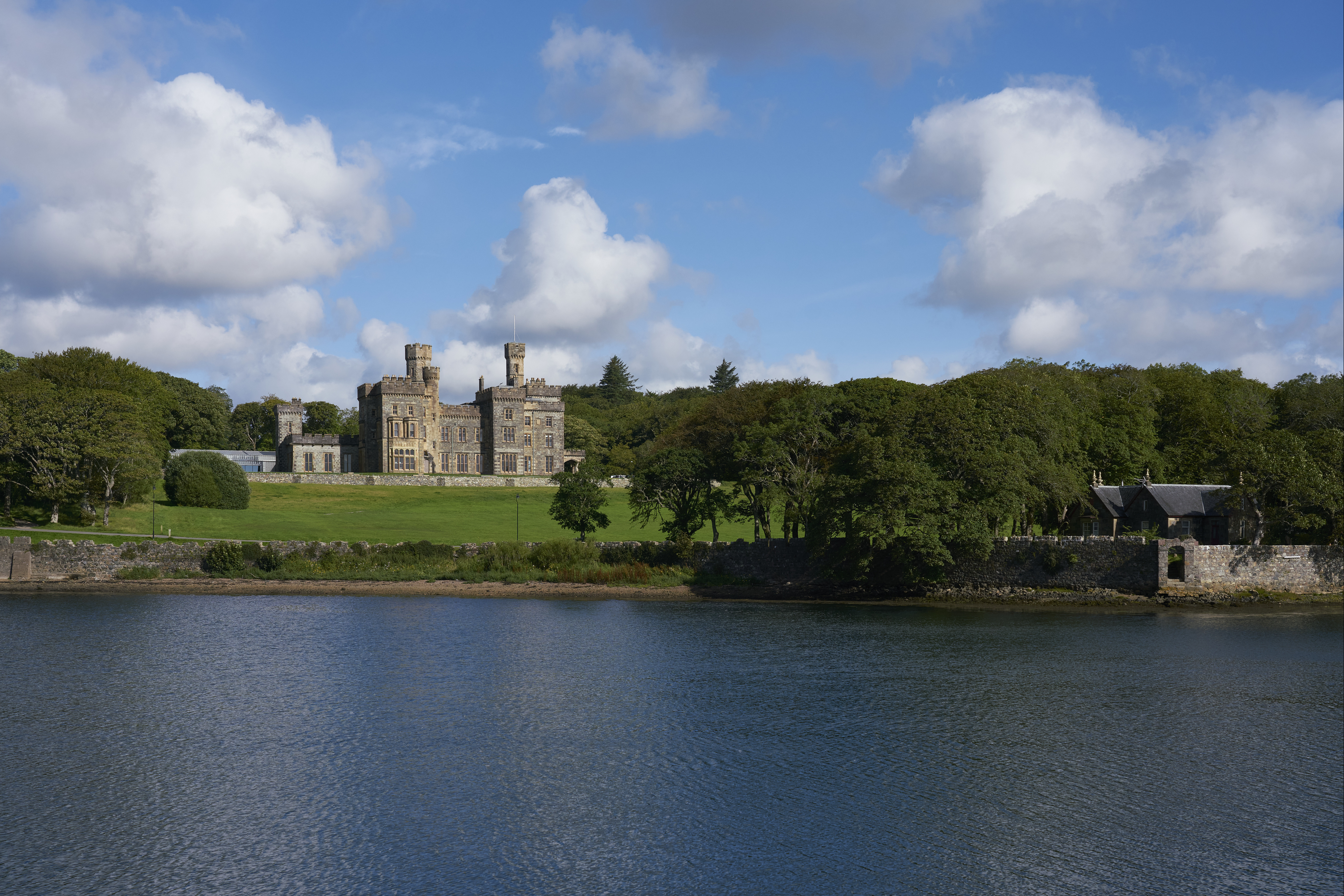 Lews Castle standing among trees above the harbour at Stornoway, viewed across the water