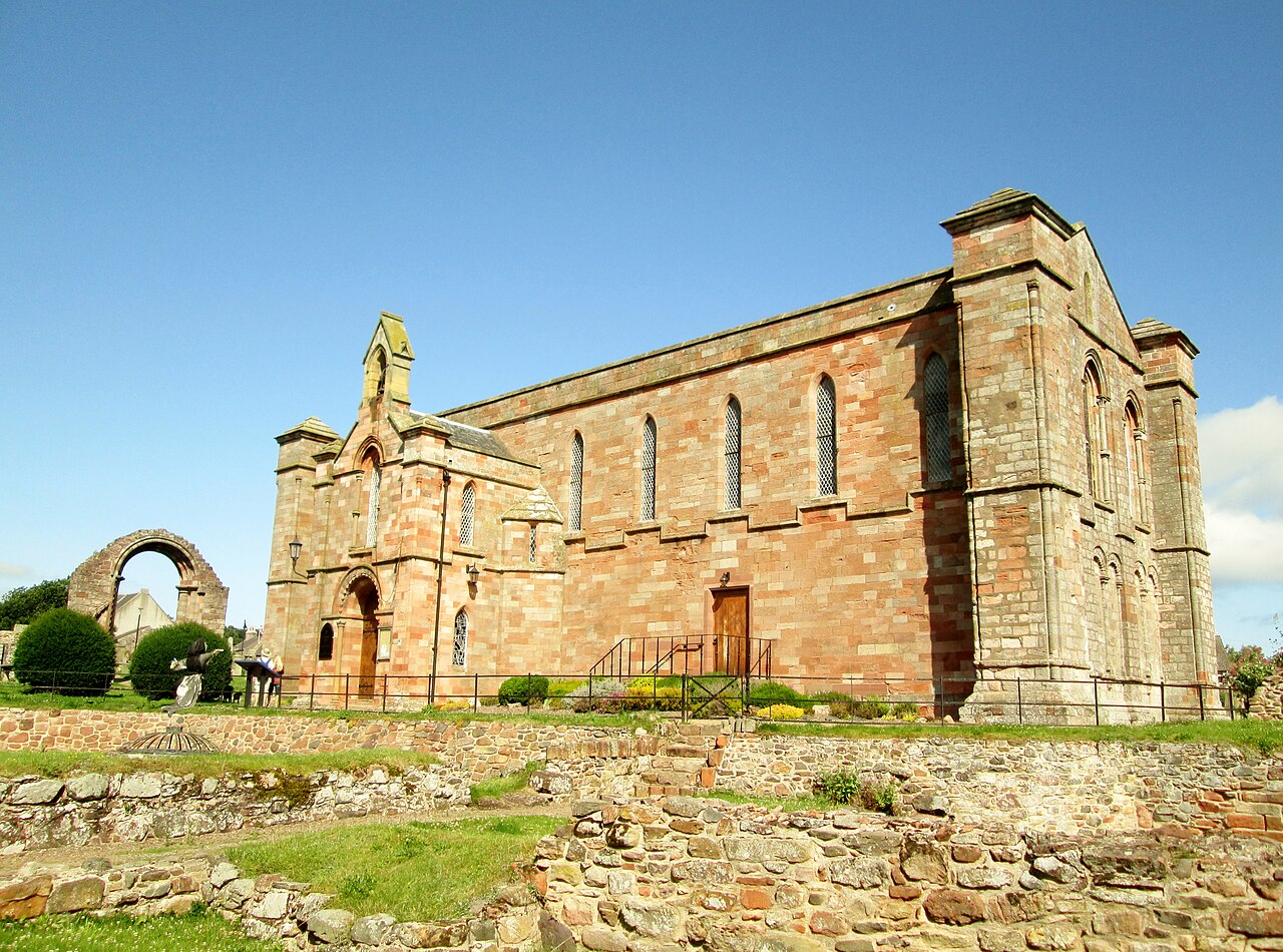 Coldingham Priory Church and adjoining medieval priory remains viewed across the grounds