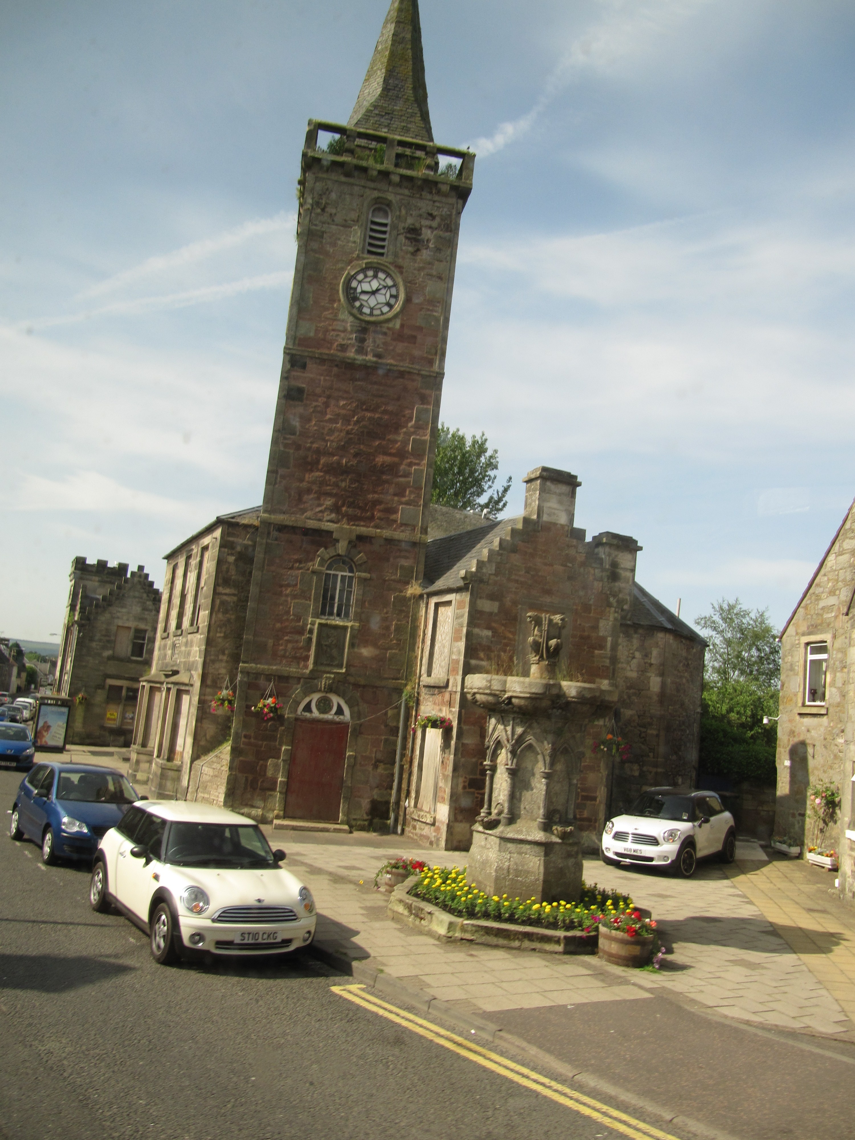 Kinross Clock Tower rising above the former civic buildings and fountain on High Street