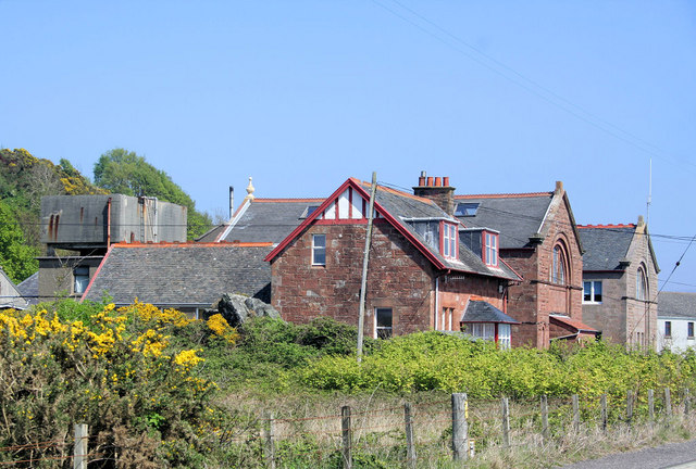 Stone gables and slate roofs of the marine biological station at Millport, seen from beside the coastal road.