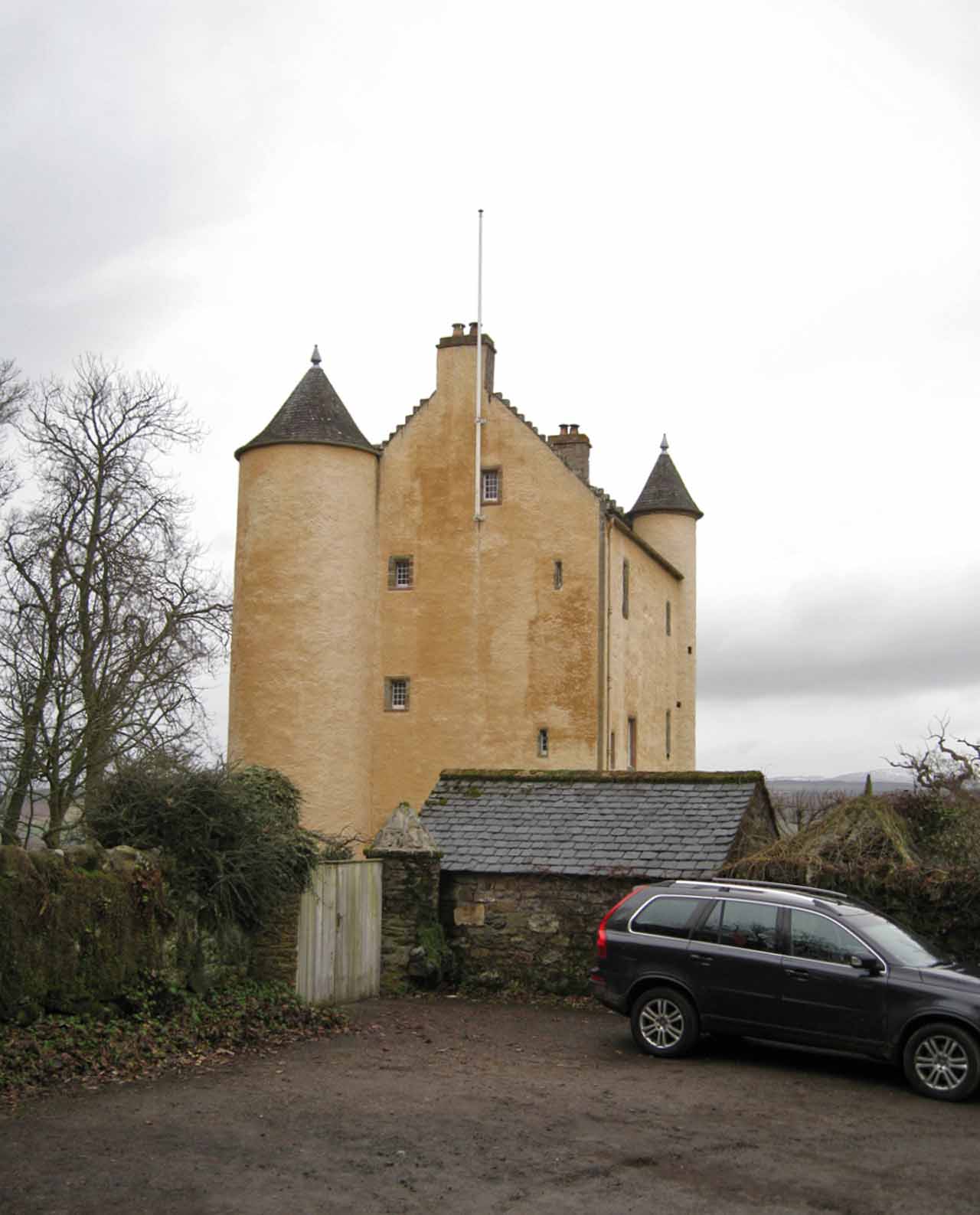 Kinkell Castle, a tall harled tower house with steep roofs and two round stair turrets, viewed from the south-east.