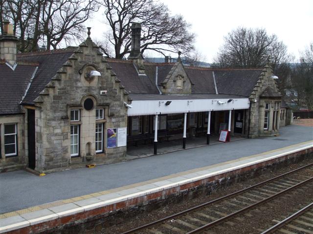 Pitlochry Railway Station’s stone platform building with crow-stepped gables and sweeping roof.